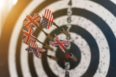Business and finance concept. Darts with British and American flags are stuck in the darts.