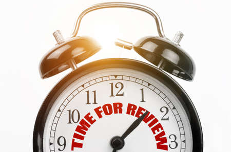 Finance and business concept. On the dial of the alarm clock the inscription - TIME FOR REVIEWの写真素材