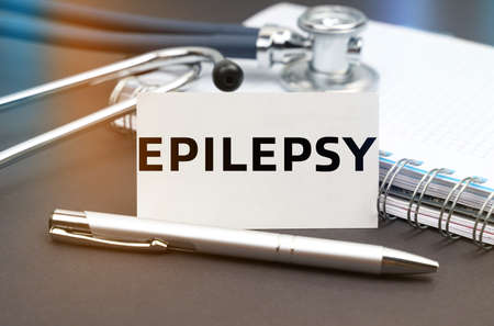 Medicine concept. On the table is a diary, a stethoscope and a business card with the inscription - EPILEPSYの写真素材
