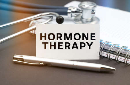 Medicine concept. On the table is a diary, a stethoscope and a business card with the inscription - HORMONE THERAPYの写真素材