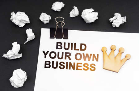 Business and finance concept. On a black background, crumpled paper and a sheet with the inscription...
