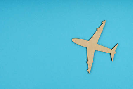 Business and tourism concept. The wooden airplane flies up. Isolated on a blue background.