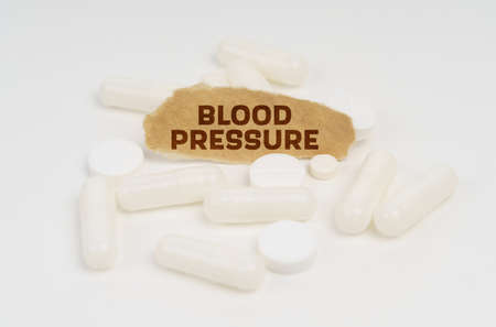 Medicine and health concept. On a white background pills and a piece of paper with the inscription - BLOOD PRESSUREの写真素材