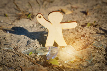 Environmental concept. A figurine of a man pays attention to the broken glass