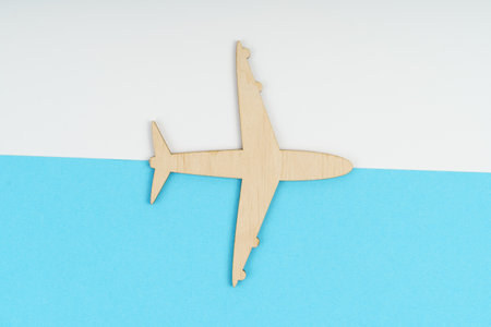 Transport concept. Half white and blue background on which a wooden plane.の写真素材
