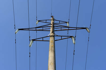 Energy concept. Power line distribution pole against the blue sky.
