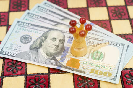 Business and success concept. On the chessboard there is money on which the king stands.の写真素材