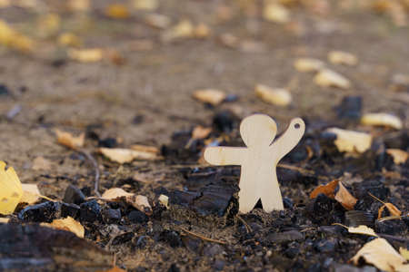 Environmental concept. The wooden figurine indicates the ashes from the fire.の写真素材