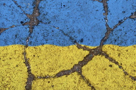 Flag of Ukraine on the cracked asphalt. The concept of crisis, default, economic collapse, pandemic, conflict, terrorism in the country. Out of focus imageの写真素材