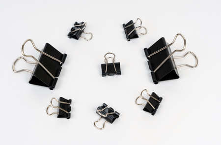 Office. Black clips of different sizes are on a white background.