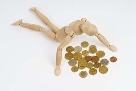 Business concept. The wooden man crawled to the coin. Isolated on white background.