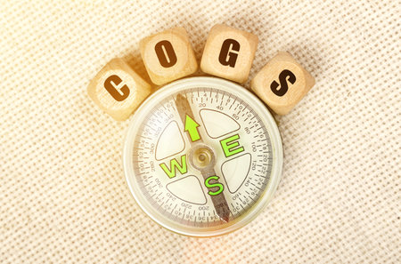 Business concept. On the table is a compass and cubes with the inscription - COGSの写真素材