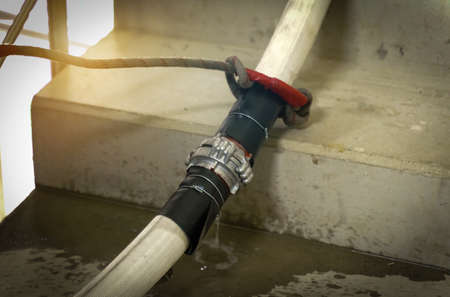 Emergency incident concept. A fire hose is laid in the flight of stairs. Close-up of the connection...