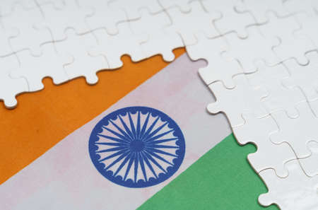 National concept. There are white puzzles on a table above the flag of India.の写真素材
