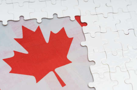 National concept. There are white puzzles on a table above the Canadian flag.の写真素材