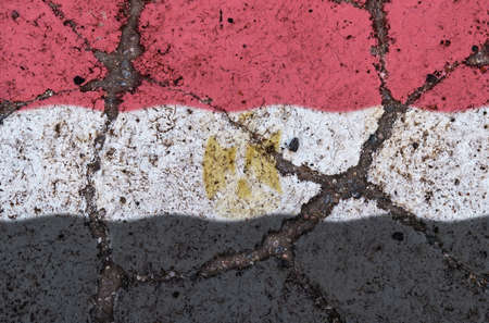 Flag of Egypt on the cracked asphalt. The concept of crisis, default, pandemic, conflict, terrorism. Out of focus imageの写真素材