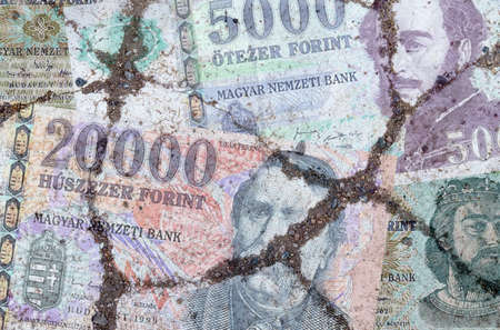 Business and finance concept. On the cracked asphalt there is an image of the Hungarian Forint.の写真素材