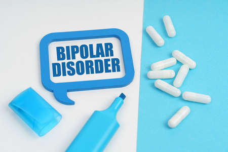 On the white and blue surface are a marker, tablets and a plate inside which the inscription - BIPOLAR DISORDERの写真素材