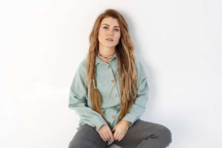 Portrait of a business woman sitting on the floor looking at the camera. Isolated over white background.の写真素材