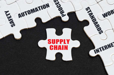 Industry concept. On a black background, puzzles with inscriptions, on a separate puzzle there is an inscription - SUPPLY CHAINの写真素材