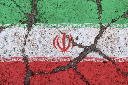 Iraqi flag on cracked asphalt. The concept of crisis, default, economic collapse, pandemic, conflict, terrorism in the country. Out of focus imageの写真素材
