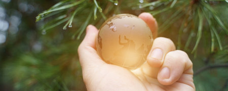 Environment concept. World earth day. Hands are holding a glass planet.