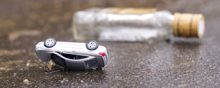 Occurrence. Traffic accident - an overturned car with a bottle of alcohol in the background.の写真素材