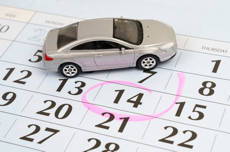 Planning. There is a toy car on the calendar with the date stamped. A planned gift, service, renovation, or travel.の写真素材