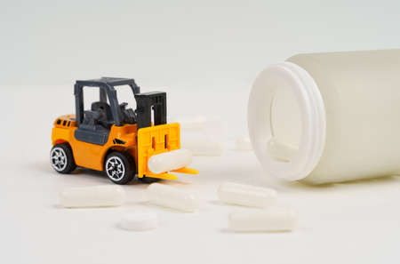 Scheduled medication intake. A loader carries pills, a jar of medicines and pills are nearby....