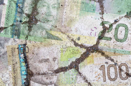 Business and finance concept. On the cracked asphalt there is an image of the Canadian dollar.の写真素材