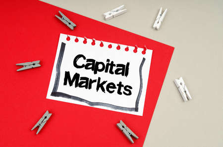 Business and finance concept. Clothespins and a sheet of notebook with the inscription - Capital Marketsの写真素材