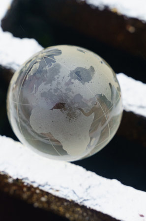 Environmental concept. A glass globe - a planet, lies on the grate of a drain pit for collecting...