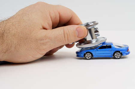 Automotive diagnostics. A stethoscope lies on the roof of a toy car. Car diagnostics, repair and...