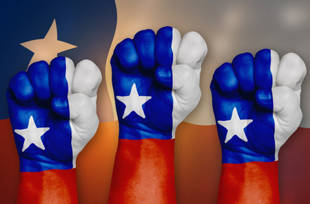 The Chile flag is drawn on a clenched fist and in the background.の写真素材