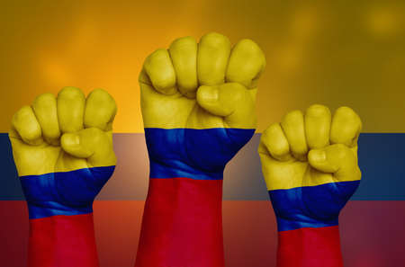 The Colombian flag is drawn on a clenched fist and in the background. The concept of protest, power and strength.の写真素材