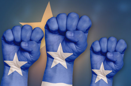 The Somalia flag is drawn on a clenched fist and in the background. The concept of protest, power and strength.の写真素材