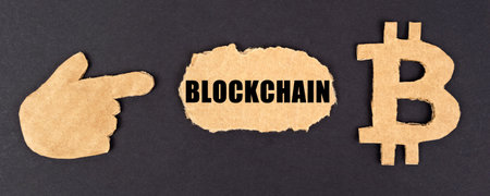 business and technology concept. On a black background, cardboard figures of the bitcoin symbol and...