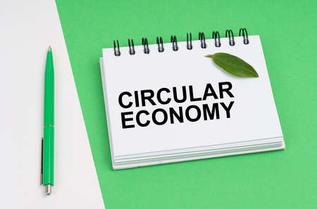 ecological concept. On a white-green background lies a pen and a notepad with the inscription -...