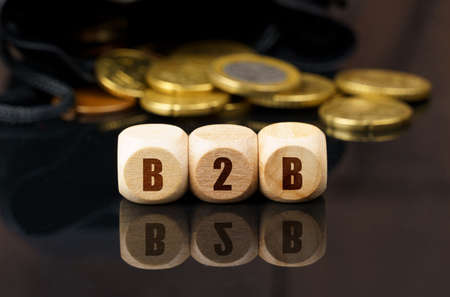 On a black surface are coins and cubes with the inscription - B2Bの写真素材