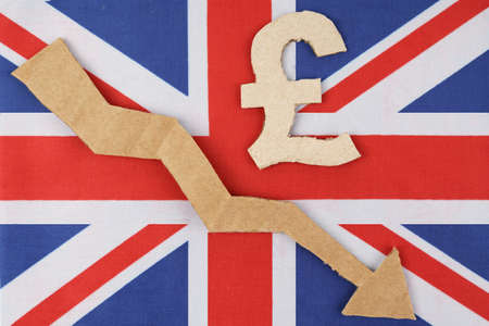 Decrease statistics concept. The flag of Great Britain has the pound symbol and an arrow pointing...