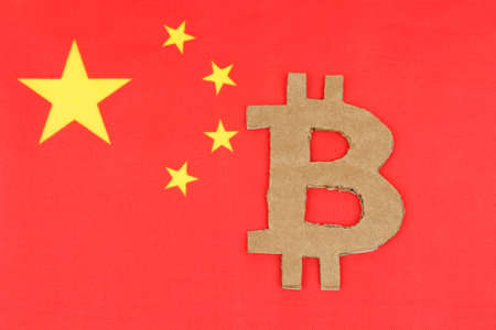 Cryptocurrency concept. On the background of the flag of China lies the symbol of bitcoin.の写真素材