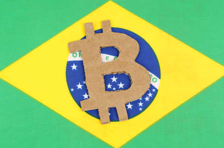 Cryptocurrency concept. On the background of the flag of Brazil lies the symbol of bitcoin.の写真素材
