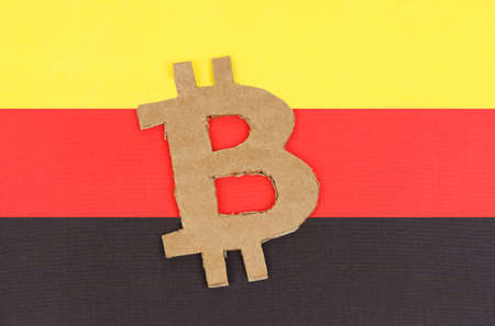 Cryptocurrency concept. On the background of the flag of Germany lies the symbol of bitcoin.の写真素材