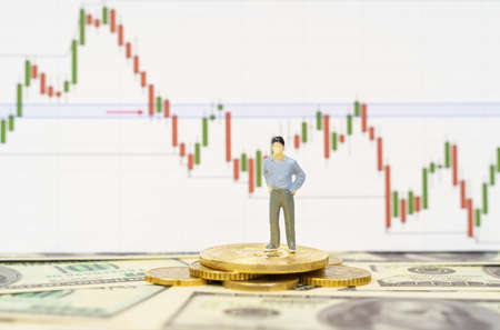 Cryptocurrency and business concept. There are coins, bitcoins and a miniature figurine of a person...