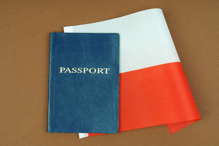 Migration concept. On a brown surface lies a passport inside which is the flag of Poland.の写真素材