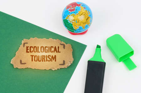 Ecological and industrial concept. On the table is a globe and a marker, on a green background there...