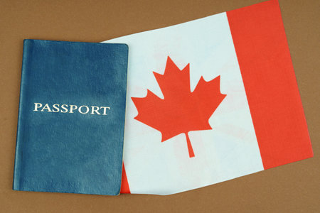 Migration concept. On a brown surface lies a passport inside which is the flag of Canada.の写真素材