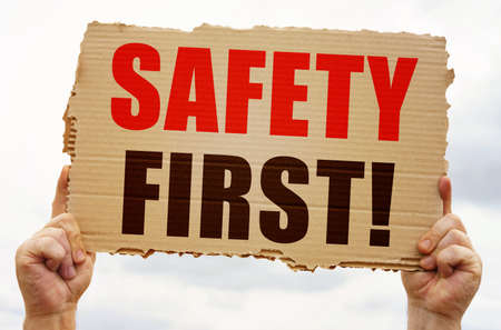 industrial concept. In the hands of a man is a cardboard sign with the inscription - Safety firstの写真素材