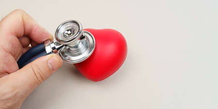 medical concept. A man holds a stethoscope in his hand to listen to the heart. close-up. Banner with...