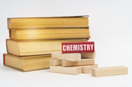 education concept. On a white surface, a stack of books and wooden blocks, on a red block there is an inscription - Chemistryの写真素材